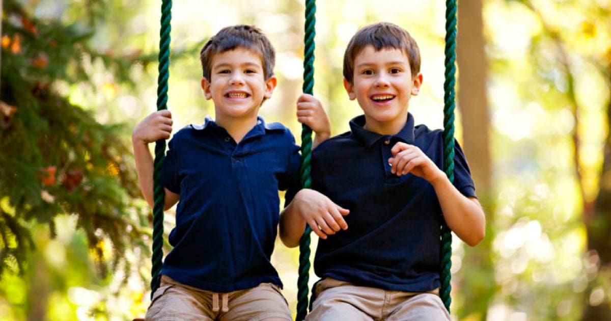 Austin, on left, and Braedan, on right, are all smiles on the swings