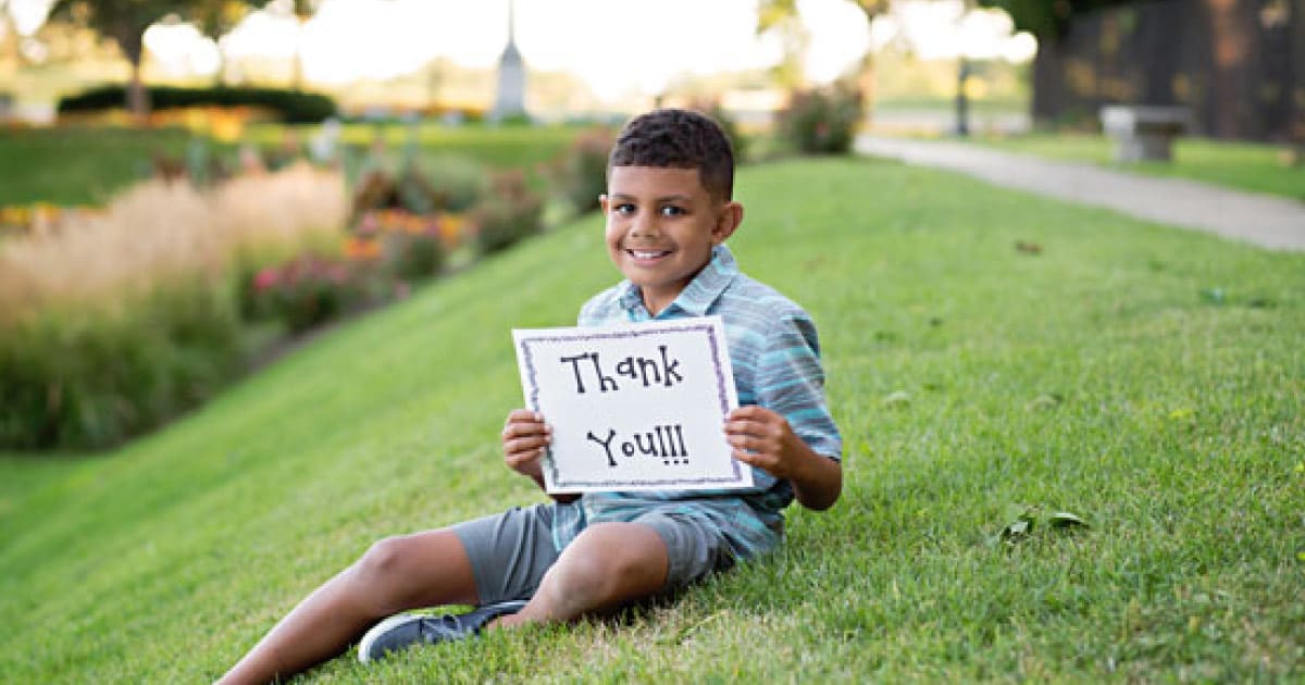 Isaac holding sign saying thank you