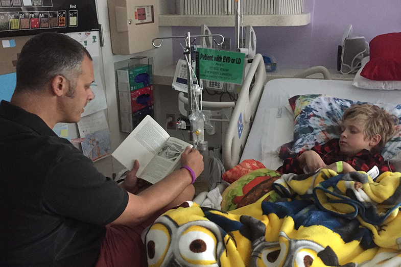 Dan reading to his son Sullivan in the hospital.