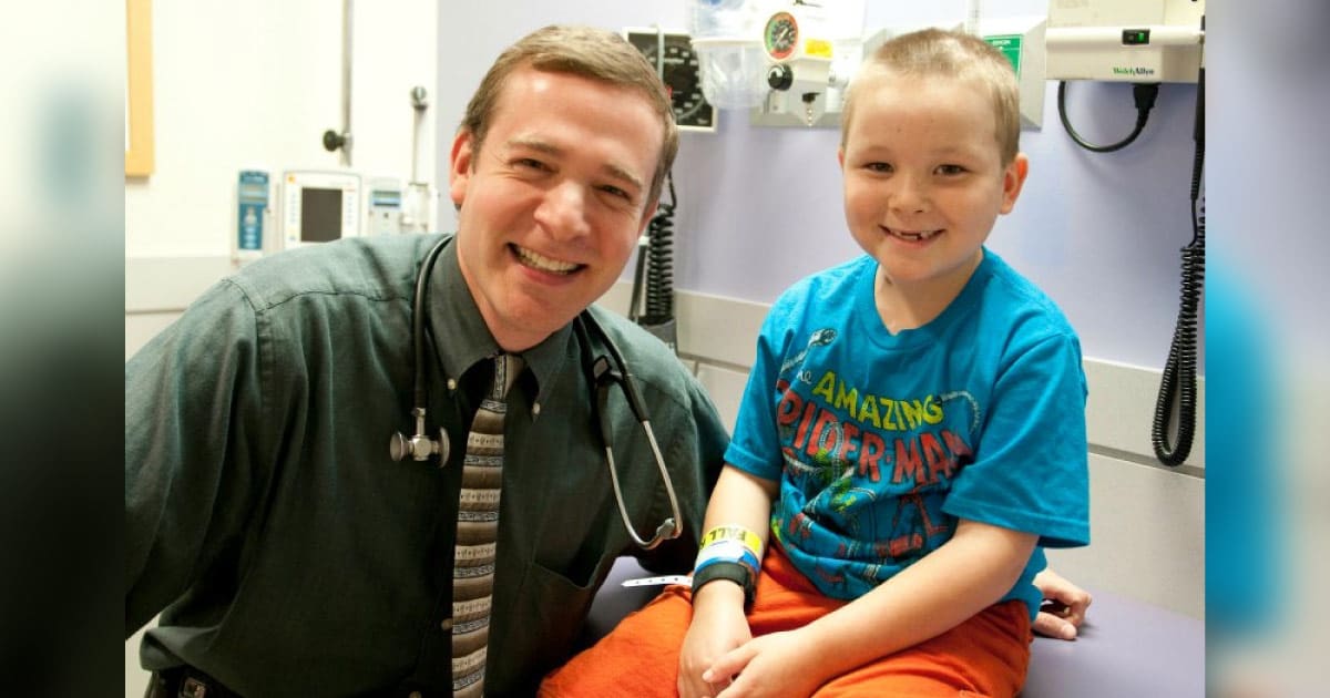 Dr. Friedman smiles with a young patient in an exam room at Children's of Alabama.