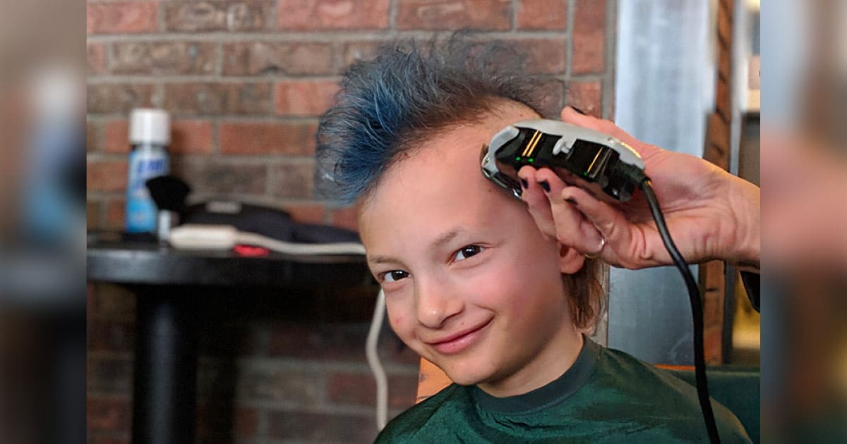 Micah with a blue mohawk, getting head shaved