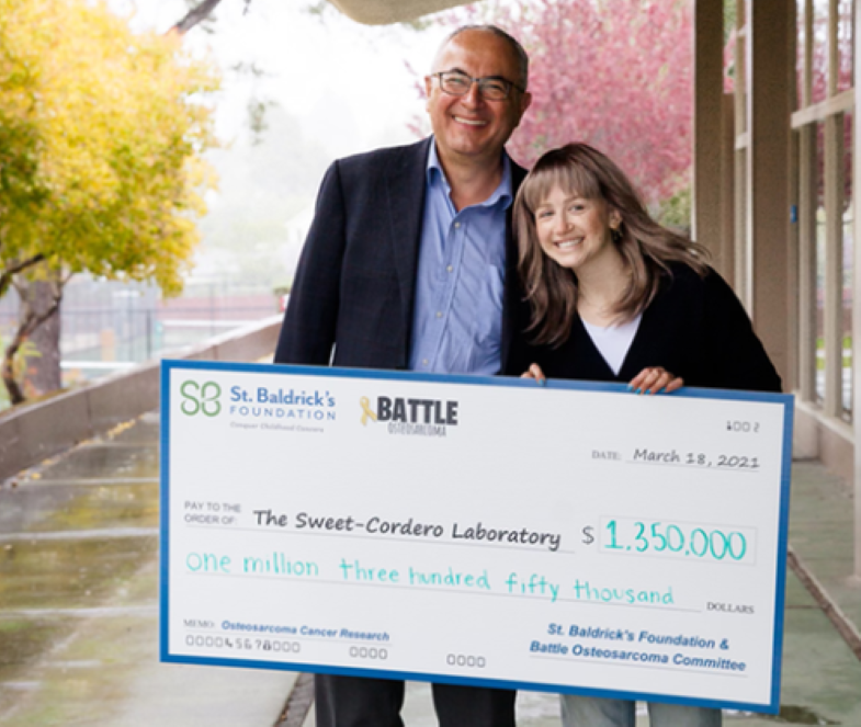 Dr. Sweet-Cordero and his patient, Charlotte, holding a $1,350,000 check.