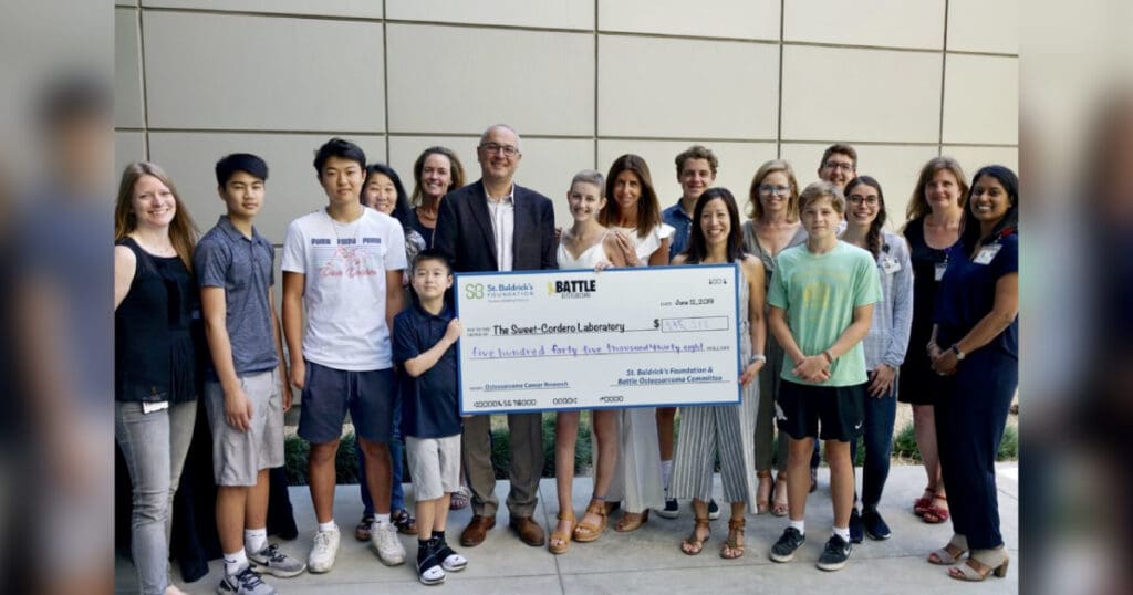 Volunteers hold a large check