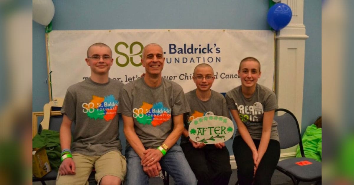 Greta sitting at a SBF event with dad and brothers