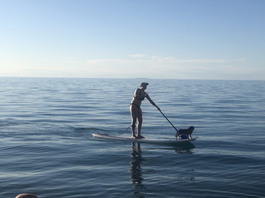 Martha paddle boarding with her dog, Scruffy