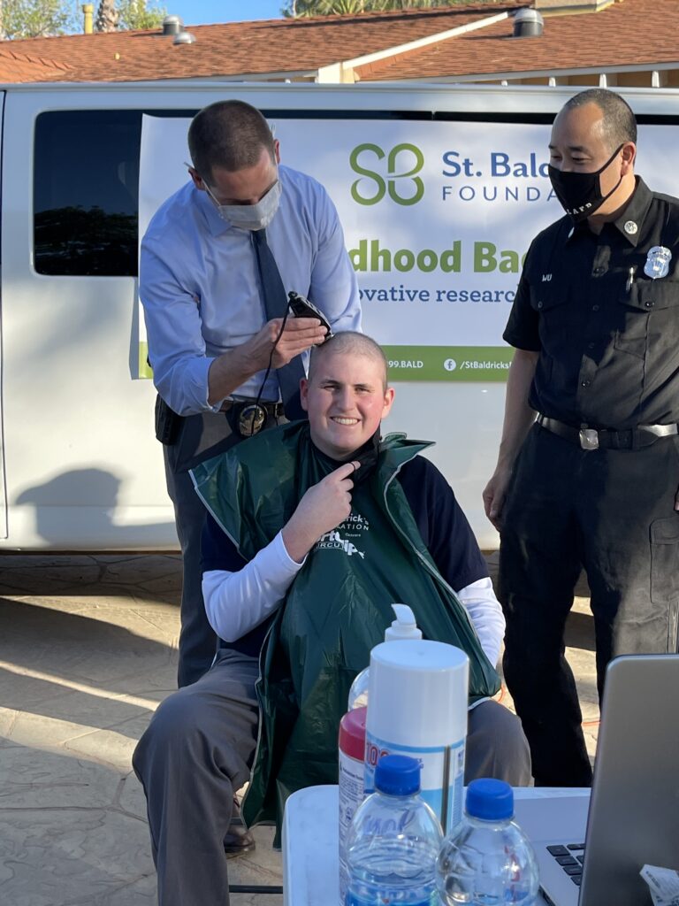 Cancer warrior Sam shaving his head at a local head-shaving event