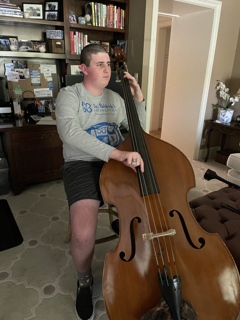cancer warrior Sam playing the cello at home.