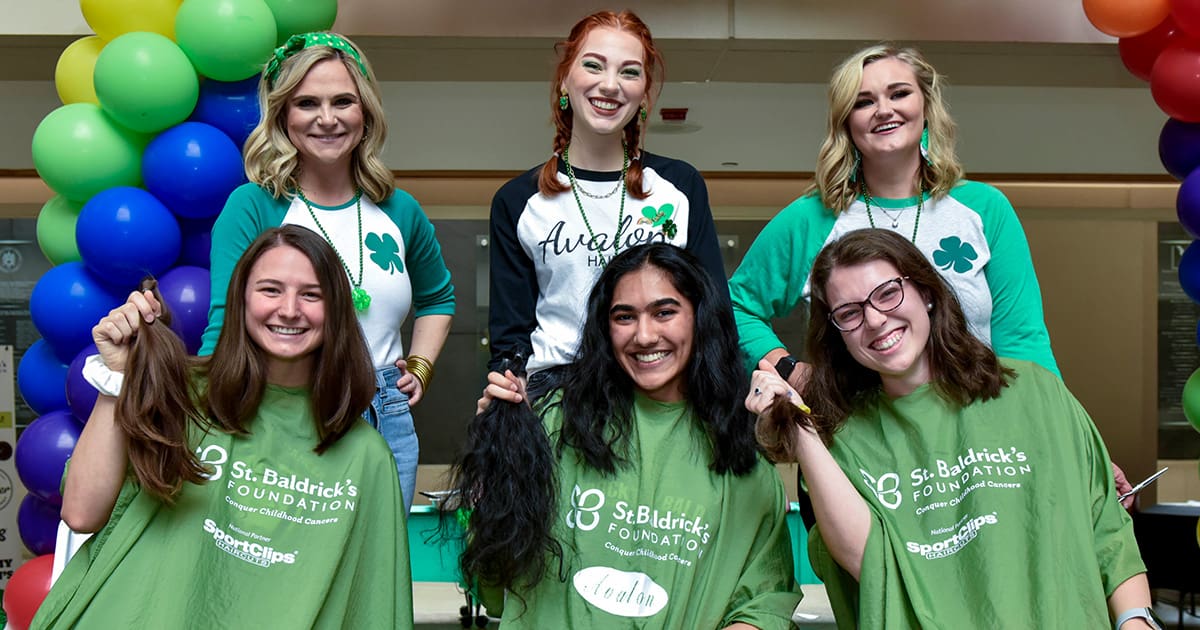 Young women holding hair donations from a St. Baldrick's head-shaving event