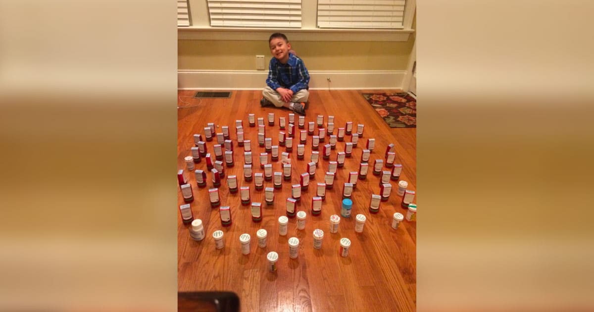 Scot sitting on floor surrounded by many pill bottles from treatment