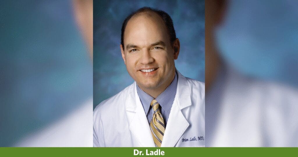 A male showcasing a smile, sporting a lab coat.