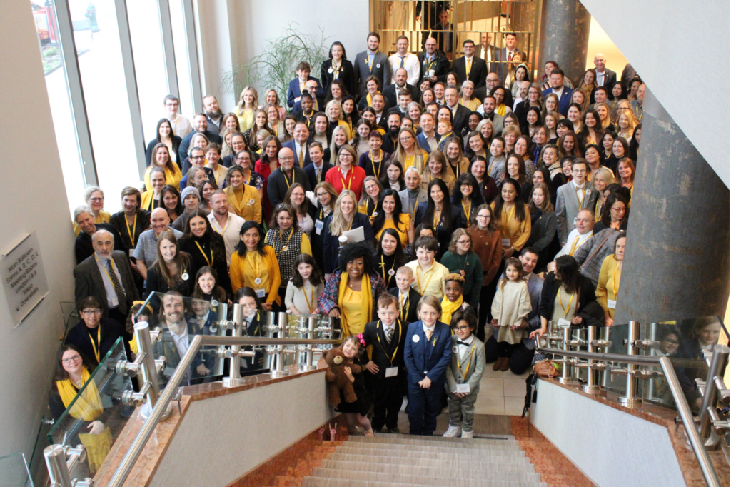 A group of folks at the end of a staircase, smiling at the camera