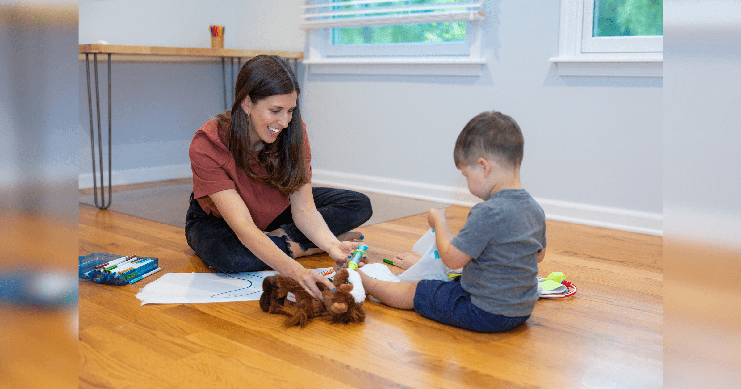 A woman and a child engaged in play with a soft stuffed animal, sharing smiles and laughter in a warm environment.