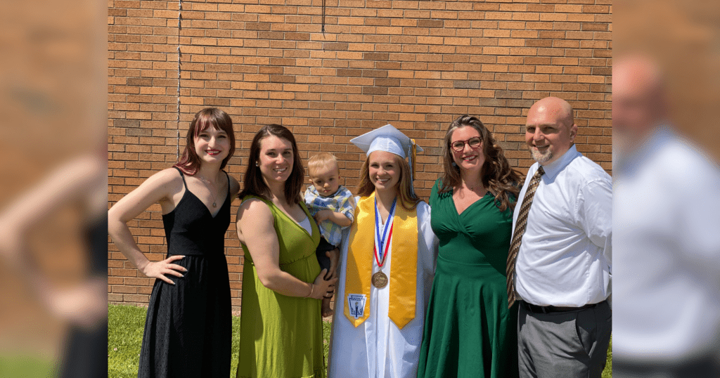 A family proudly poses together for a photo to celebrate their graduation milestone.