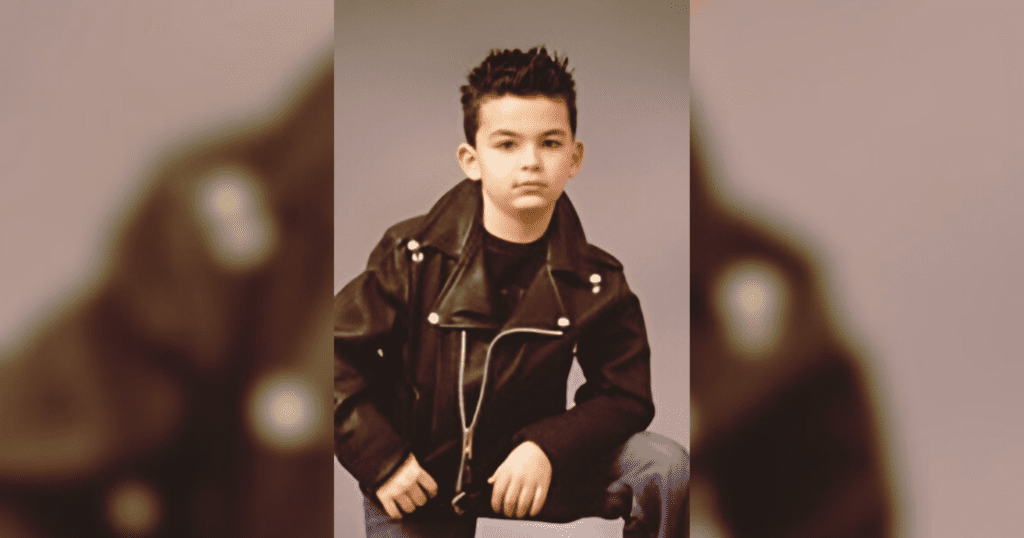 A young boy dressed in a leather jacket and jeans, exuding a cool and confident demeanor.