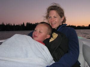A woman and a child sitting together on a small boat, enjoying a sunny day on the water.
