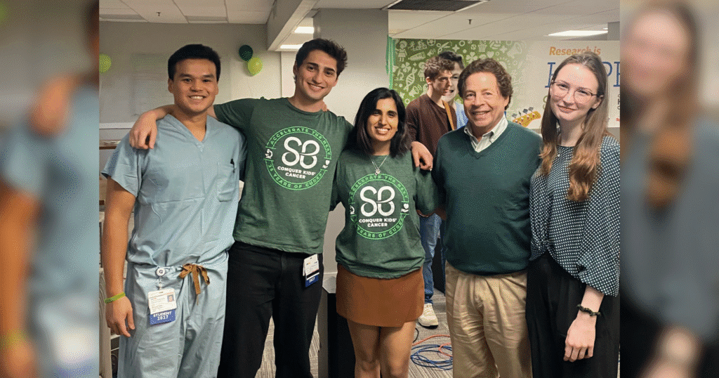 A group of diverse colleagues smiling and posing together for a photo in a modern office setting.