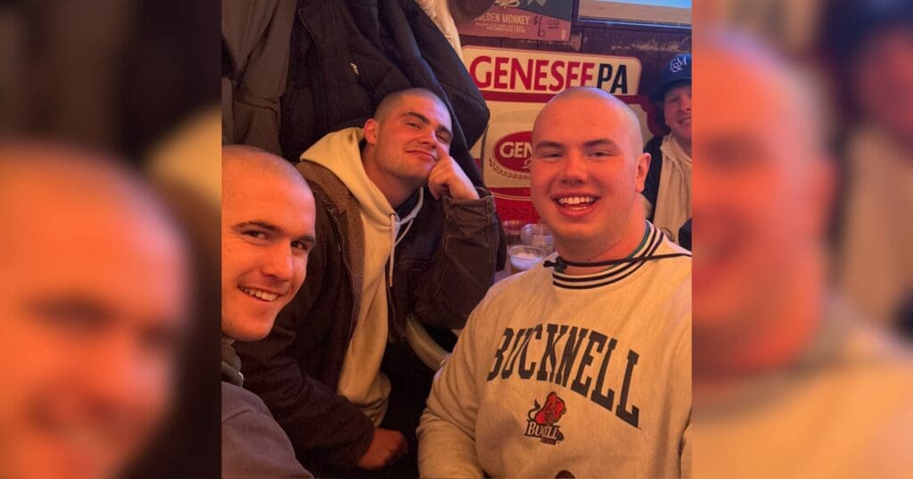Three men are smiling and posing together for the camera, showcasing a friendly and cheerful atmosphere.