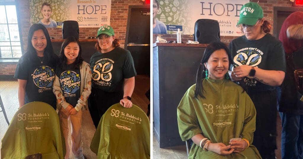 A group of three people in matching St. Baldrick's shirts stand smiling in front of chairs. To the right, a woman gets her hair shaved at the event.