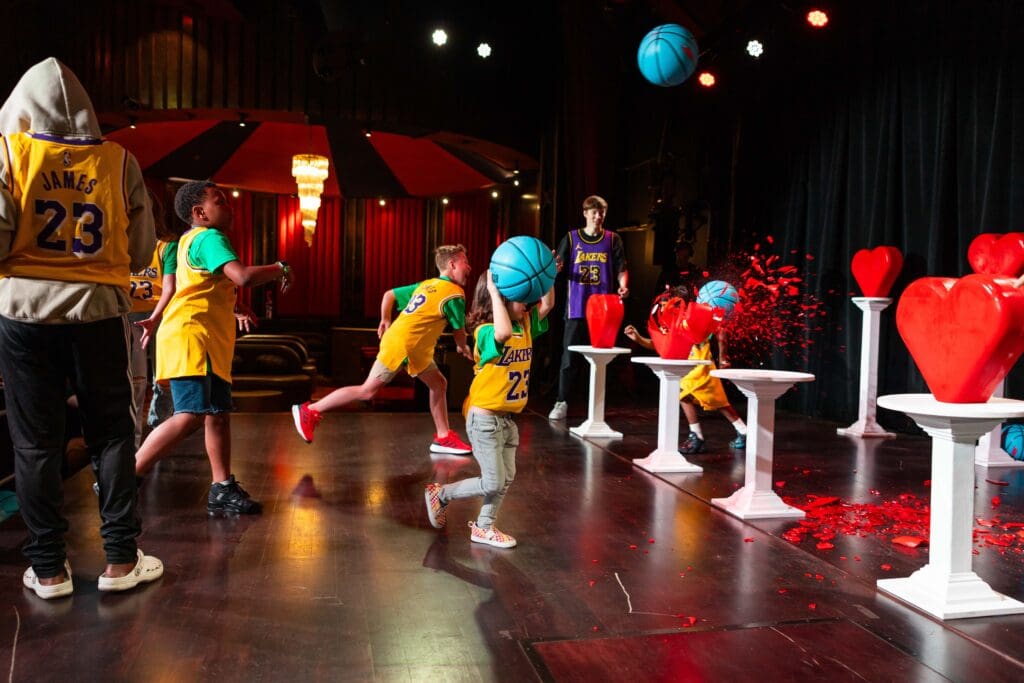 A group of people joyfully playing with colorful balloons on a stage, creating a festive atmosphere.