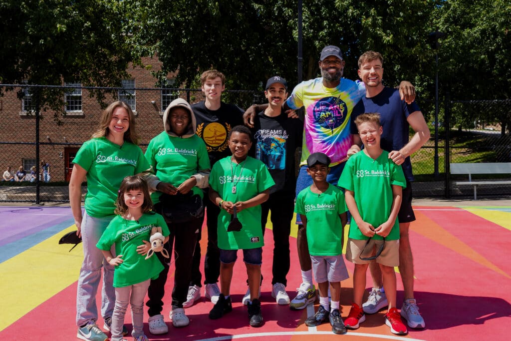 A group of individuals wearing green shirts smiles together for a photo, showcasing camaraderie and teamwork.